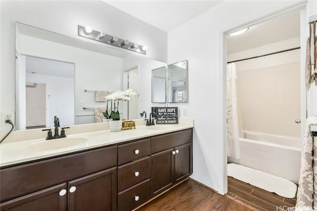 bathroom with hardwood / wood-style floors, vanity, and shower / tub combo with curtain