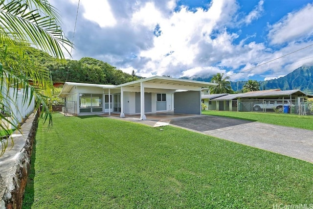 view of front of home featuring a mountain view, a front lawn, and a carport