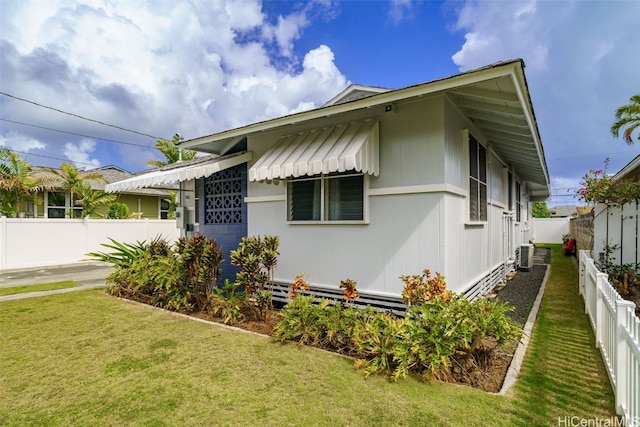 view of front of home with central AC unit and a front lawn