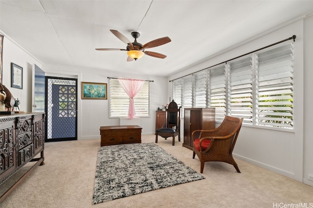 sitting room with ceiling fan and light colored carpet