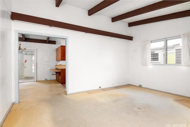 carpeted spare room with beam ceiling and a chandelier