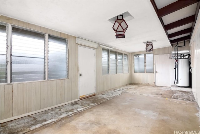 garage featuring gas water heater and wood walls