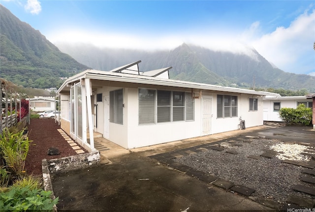 exterior space featuring a mountain view, stucco siding, and a patio