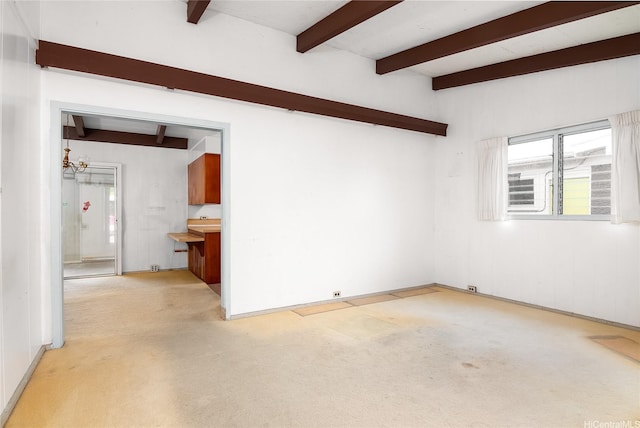 empty room with beam ceiling, a notable chandelier, and light carpet