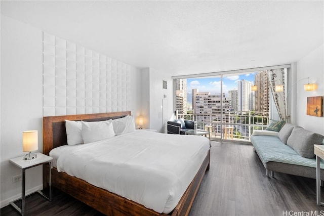 bedroom featuring floor to ceiling windows and dark hardwood / wood-style floors