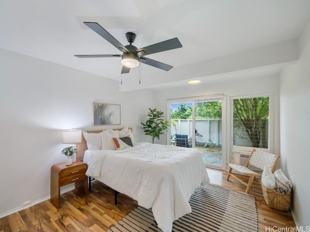 bedroom featuring access to exterior, hardwood / wood-style floors, and ceiling fan