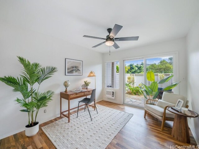 office area with wood-type flooring, a healthy amount of sunlight, a wall mounted AC, and ceiling fan