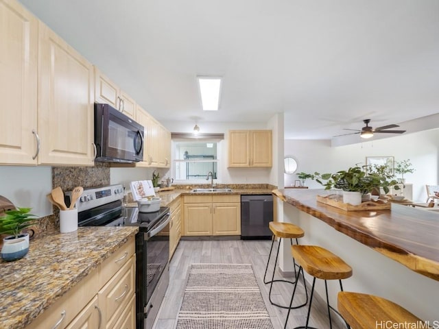 kitchen featuring sink, light stone counters, light brown cabinets, ceiling fan, and black appliances