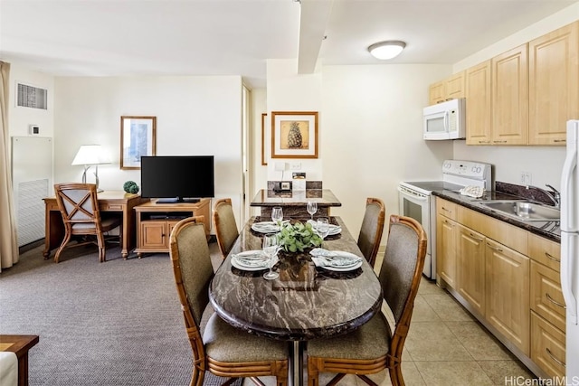 dining room with light colored carpet, visible vents, and light tile patterned floors