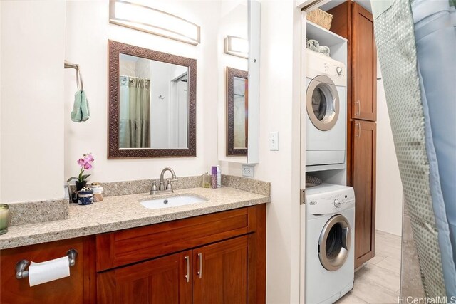 laundry area featuring stacked washer and dryer and a sink