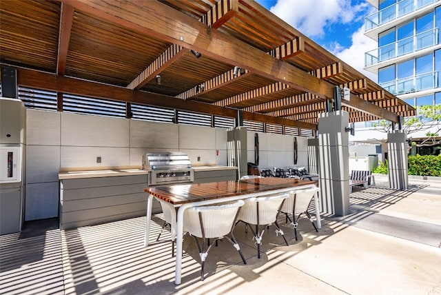 view of patio / terrace with exterior kitchen, a pergola, grilling area, and a bar