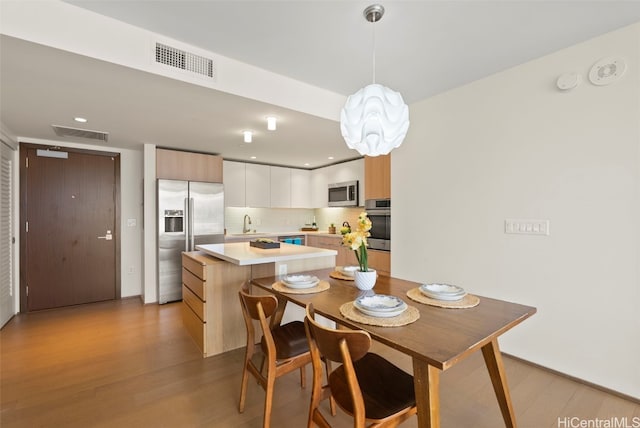 dining space featuring sink and light hardwood / wood-style floors