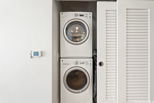 washroom with stacked washing maching and dryer