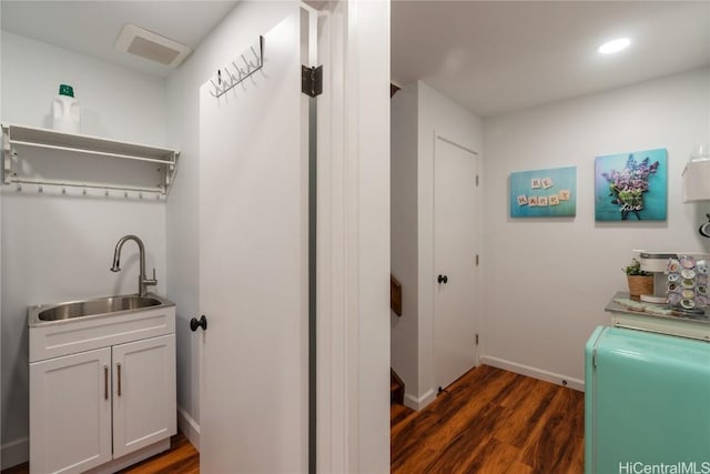 washroom with sink, cabinets, dark hardwood / wood-style floors, and separate washer and dryer