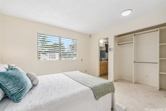 carpeted bedroom with a closet and ensuite bathroom