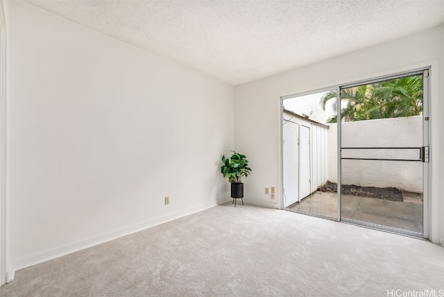 carpeted empty room featuring a textured ceiling