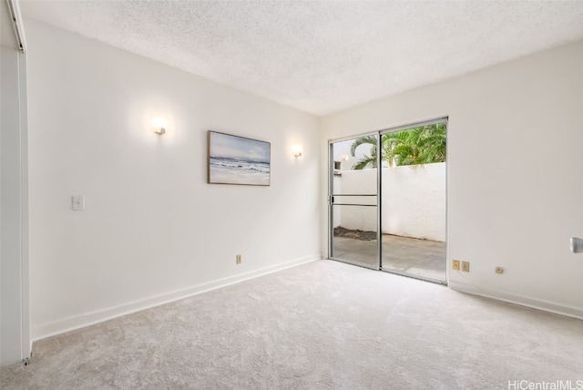 spare room with a textured ceiling and light carpet