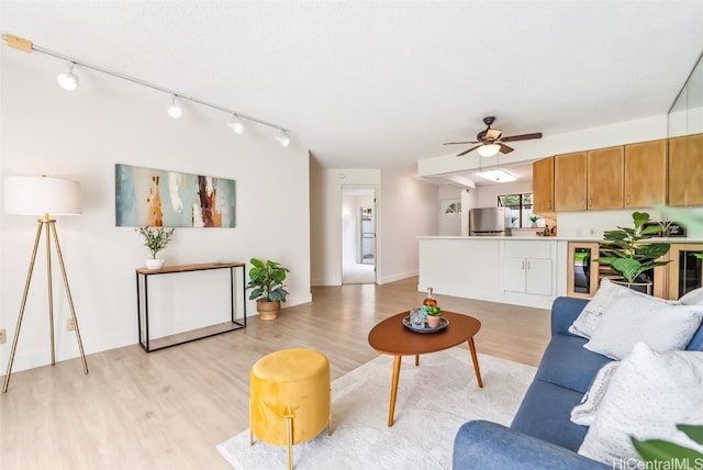 living room featuring light wood-type flooring, ceiling fan, and wine cooler