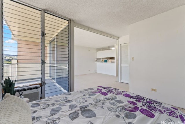 bedroom with light colored carpet and a textured ceiling