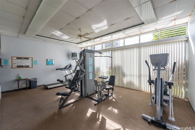 exercise room with a paneled ceiling and ceiling fan