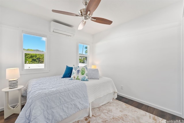 bedroom with multiple windows, a wall unit AC, dark hardwood / wood-style floors, and ceiling fan