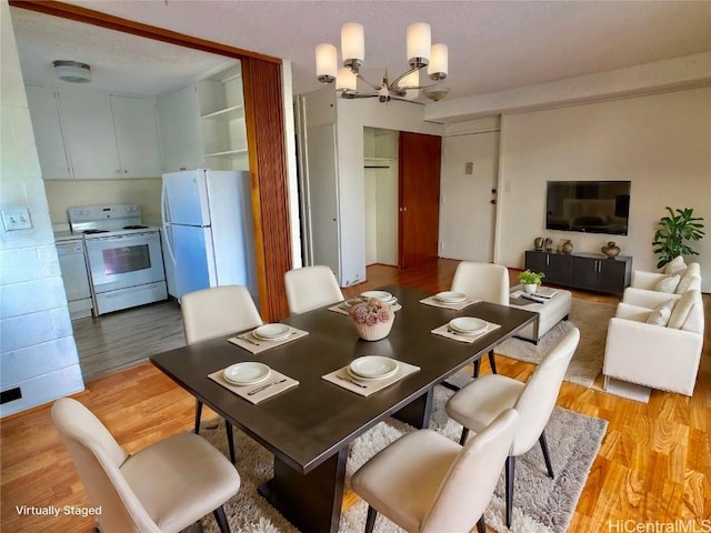 dining room with an inviting chandelier and light wood-type flooring