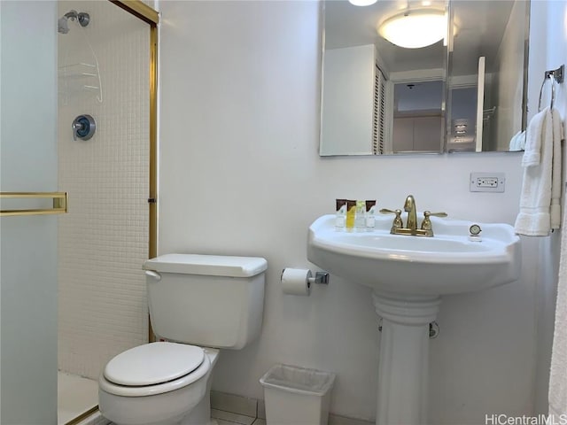 bathroom featuring toilet, sink, and a tile shower