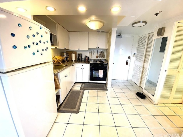 kitchen featuring light tile patterned floors, electric range, white cabinets, and white fridge