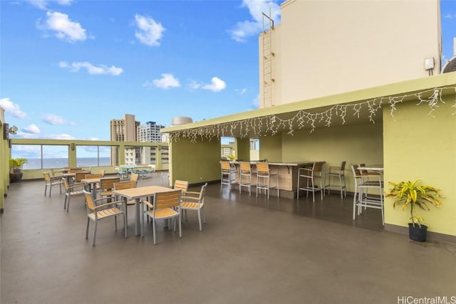 view of patio featuring a water view and exterior bar