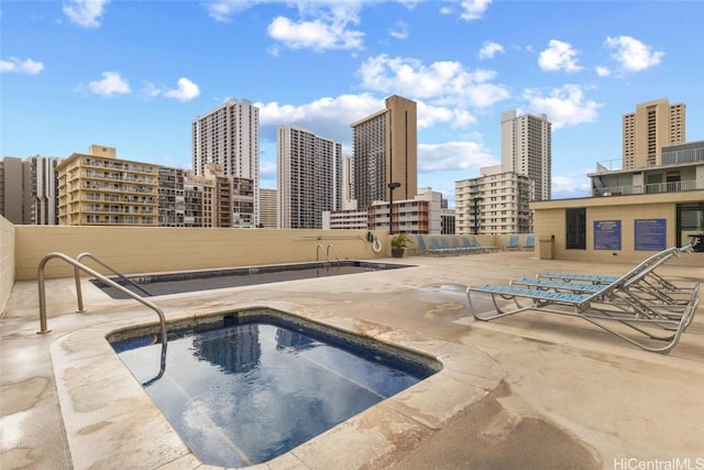 view of pool featuring a hot tub and a patio area