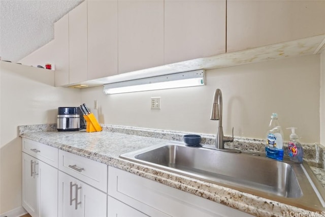 kitchen with a sink and white cabinets