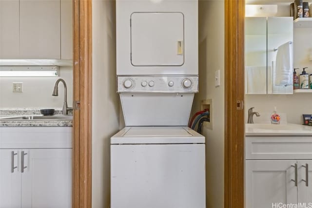 clothes washing area featuring stacked washer and clothes dryer and sink