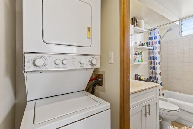 clothes washing area with stacked washer / drying machine and laundry area