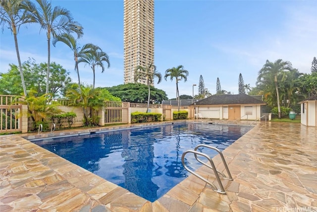 view of swimming pool featuring an outbuilding and a patio