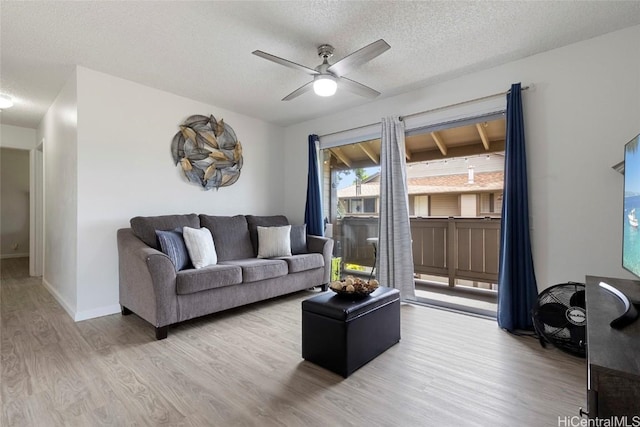 living room with hardwood / wood-style flooring, a textured ceiling, and ceiling fan