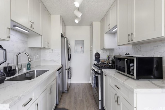 kitchen featuring sink, light stone counters, white cabinetry, and stainless steel appliances