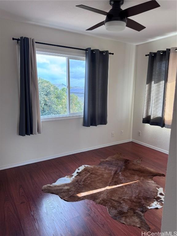 empty room featuring ceiling fan and dark hardwood / wood-style floors