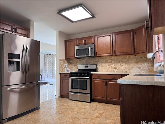 kitchen with sink, backsplash, stainless steel appliances, and a healthy amount of sunlight