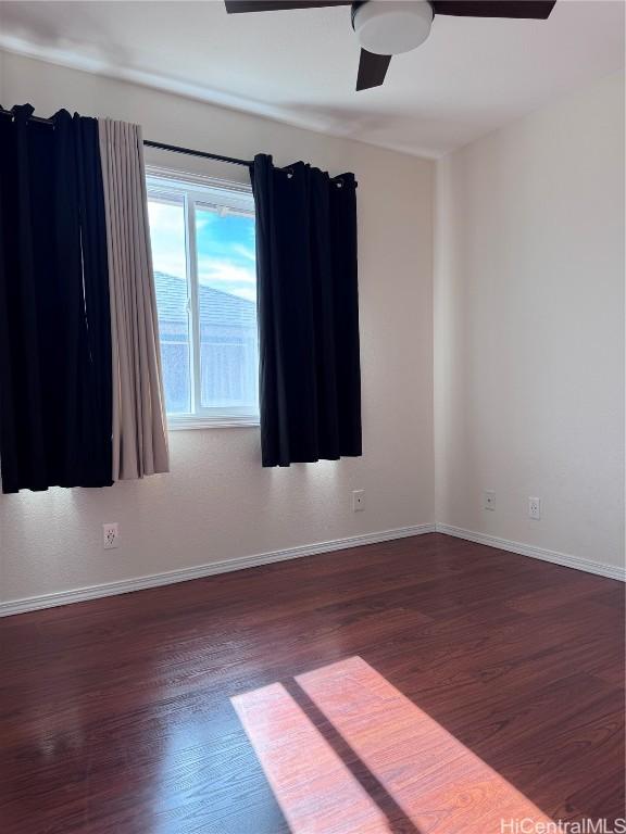 empty room with ceiling fan and dark wood-type flooring