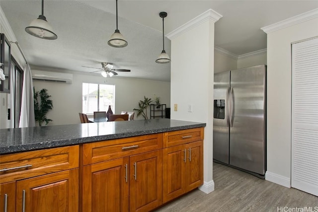 kitchen with decorative light fixtures, an AC wall unit, crown molding, and stainless steel refrigerator with ice dispenser