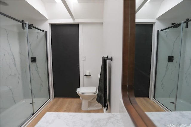 bathroom with wood-type flooring, toilet, and walk in shower