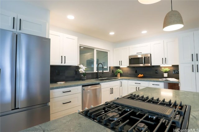 kitchen featuring sink, white cabinetry, decorative light fixtures, appliances with stainless steel finishes, and decorative backsplash