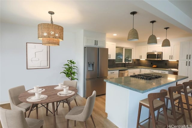 kitchen featuring pendant lighting, stainless steel appliances, and white cabinets