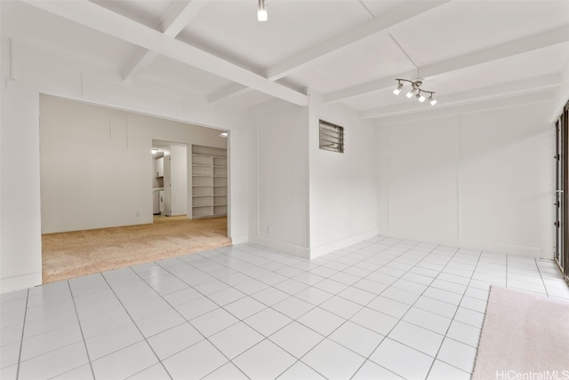 carpeted empty room featuring beamed ceiling