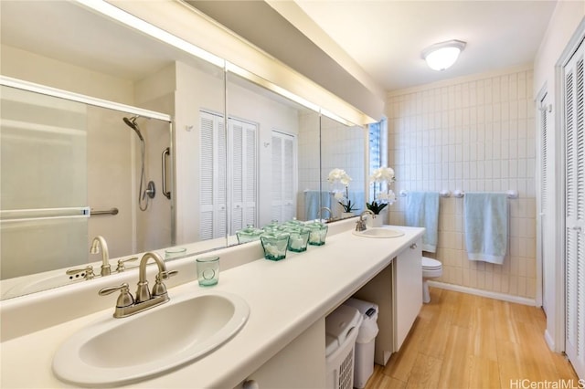 bathroom with tile walls, vanity, hardwood / wood-style flooring, and toilet