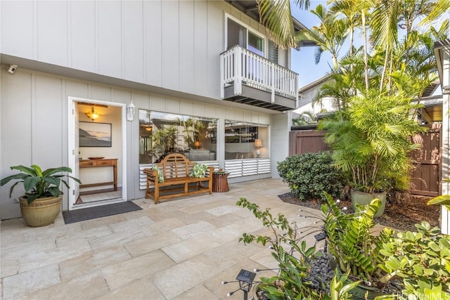 view of patio with a balcony and fence