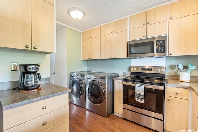 kitchen featuring appliances with stainless steel finishes, dark hardwood / wood-style flooring, washing machine and dryer, light brown cabinets, and a textured ceiling