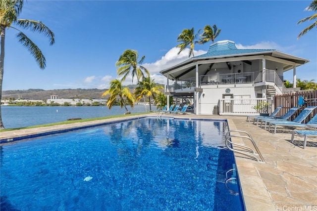 view of swimming pool with stairs, a patio, a fenced in pool, and a water view