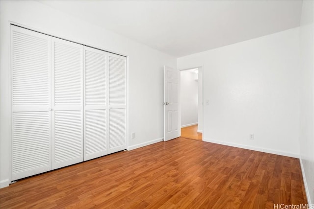 unfurnished bedroom with hardwood / wood-style flooring and a closet