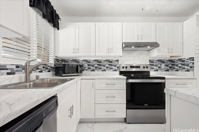 kitchen with sink, light stone counters, appliances with stainless steel finishes, white cabinets, and backsplash